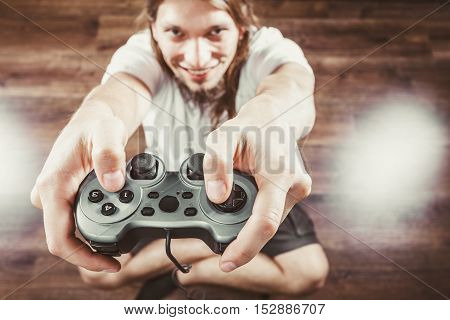 Playing games. Young smiling cheerful man play on console xbox playstation. Guy with pad joystick.