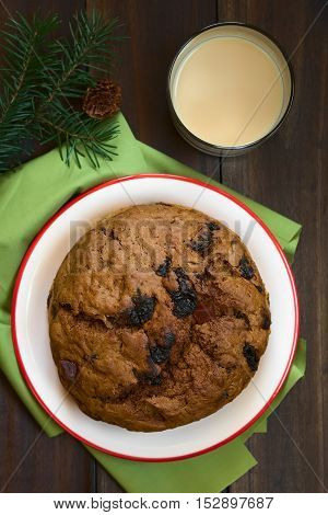 Traditional Chilean Pan de Pascua Christmas Cake made with spices dried fruits and raisins with a glass of Chilean Cola de Mono Christmas cocktail photographed overhead with natural light (Selective Focus Focus on the top of the cake)