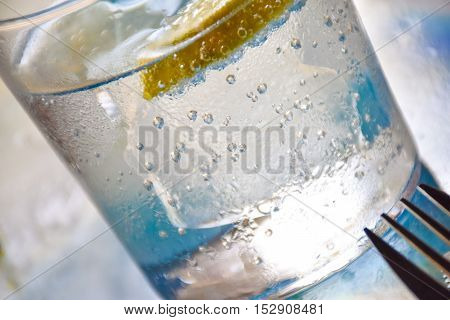 Closeup view of a glass of soda with lemon on a hot summer day