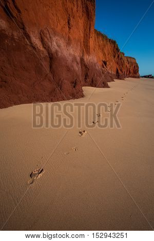 James Price Point, North of Broome in Western Australia. The spring tide had just receded leaving a perfectly untouched beach set off against the red pindan cliffs. Off with the shoes a quick walk along the beach and a detour back out of frame view 