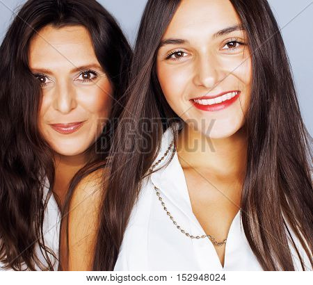 cute pretty teen daughter with mature mother hugging, fashion style brunette makeup close up, real happy family