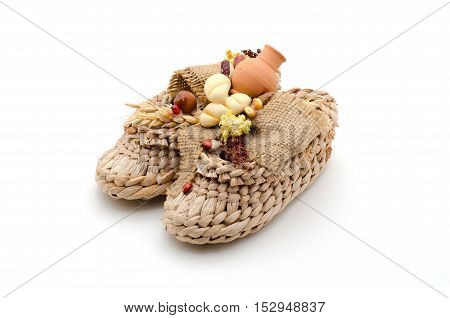 Bast shoes with products on a white background. The symbol of hearth and wealth.