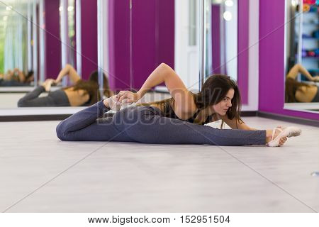 Pretty woman doing yoga in the studio