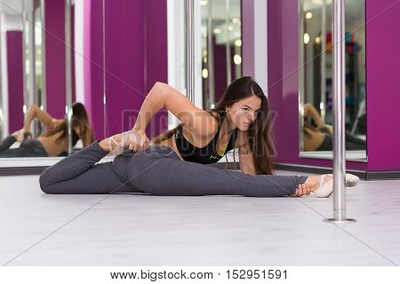Pretty woman doing yoga in the studio