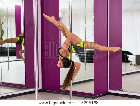 Beautiful pole dancer performing at the studio