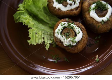 Fried mushrooms of champignon with mayonnaise on a plate