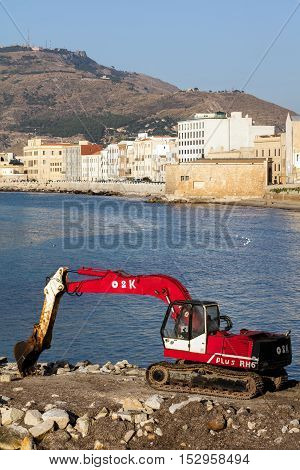 TRAPANI ITALY - AUGUST 10 2016: O&K Tracked Excavator RH6-22 on the waterfront in Trapani Sicily