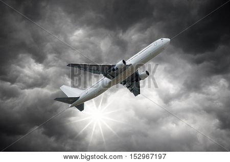 Airplane above the Sun shining from Darkclouds of storm sky