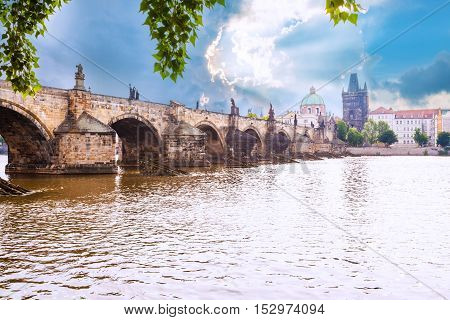 Prague, Czech Republic. Charles Bridge with its statuette, Old Town Bridge Tower, St. Francis Of Assissi Church in the background.