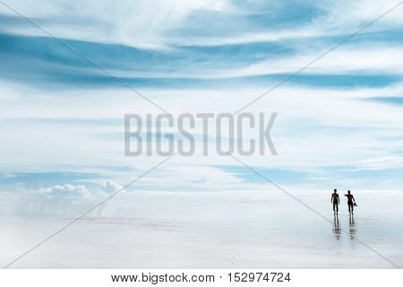 A walk through the heavens . Silhouettes of people on the beach .