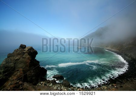 Rotsachtig strand met mist