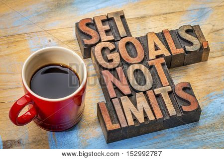 Set goals, not limits - motivational advice in vintage letterpress wood type with a cup of coffee