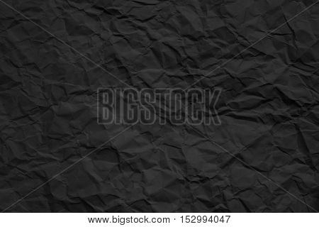 Texture of crumpled dark paper. Closeup photo.