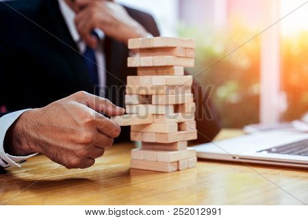 An Asian Businessman Arraging The Small Wooden Blocks On His Working Desk By Close-up, Business Cons