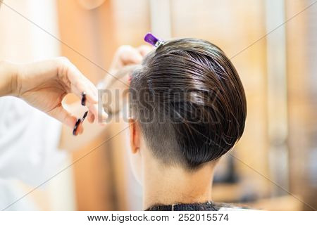 Beauty, hairstyle, treatment, hair care concept, young woman and hairdresser cutting hair at hairdressing salon. Hairdresser cuts happy girl's hair. Hairstylist serving client at barber shop