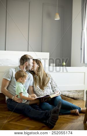 Parents Reading Book To Little Boy And Have Fun On The Floot In The Room