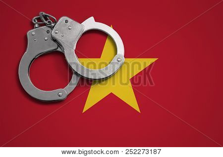 Vietnam Flag  And Police Handcuffs. The Concept Of Crime And Offenses In The Country