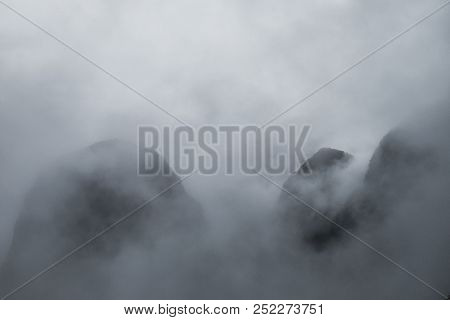 Three Peaks Of The Mountains Can Be Seen From Behind The Clouds