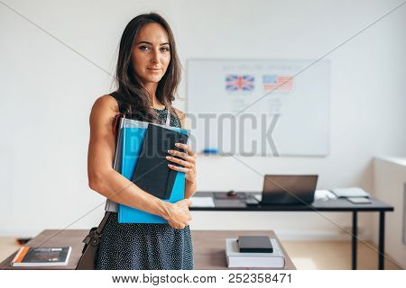 Female Student With Books Smiling And Looking At Camera