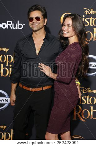 John Stamos and Caitlin McHugh at the Los Angeles premiere of 'Christopher Robin' held at the Walt Disney Studios in Burbank, USA on July 30, 2018.