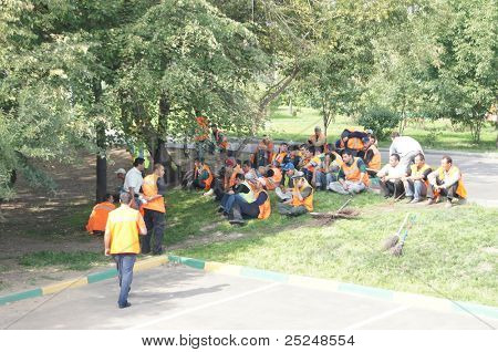 Moskva - 30 AUGUST: gæstearbejdere har en pause i en skygge af træer på 