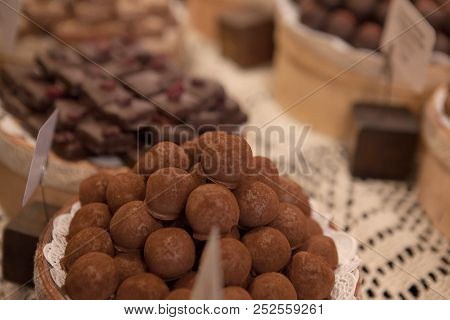 Asorted Chocolate Truffles And Pralines. Chocolate And Coconut Candies On The Counter In The Confect