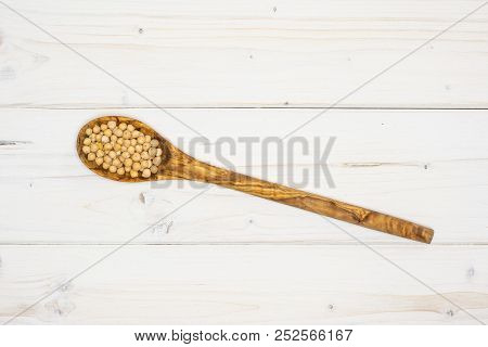 Lot Of Whole Raw Chickpeas Kabuli Variety With Olivewood Spoon Flatlay On Grey Wood