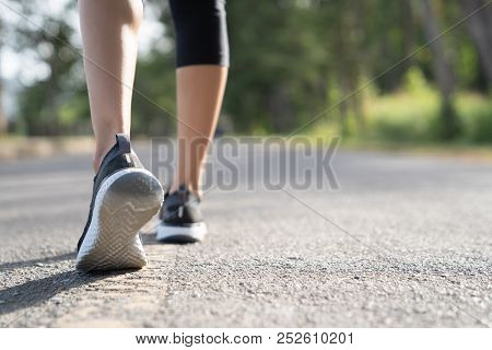 Runner Feet Running On Road Closeup On Shoe. Woman Fitness Sunrise Jog Workout Welness Concept. Youn