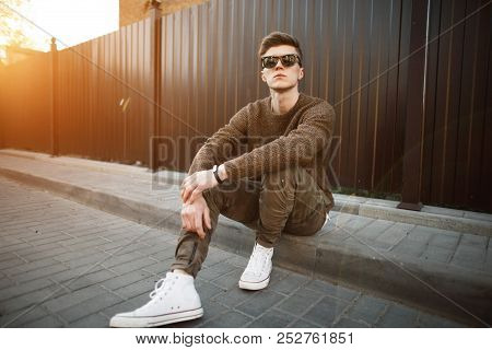Handsome Fashion Hipster Man In Stylish Sunglasses In A Fashionable Pullover And Military Stylish Pa