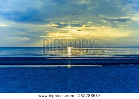 Landscape Sunset On The Beach With Light Flare On The Ocean In Cross Process Color.