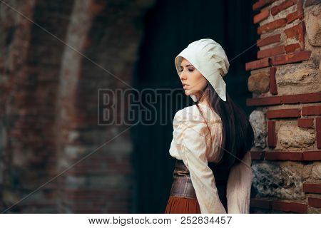 Medieval Woman In Historical Costume Wearing Corset Dress And Bonnet