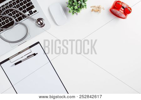 Medical Desk With Stethoscope,heart,pen,laptop,mouse And X-ray Film On White Desk.top View With Copy