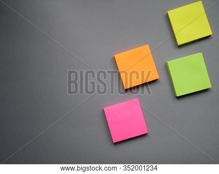 Collection Of Different Colored Sheets Of Note Papers Ready For Your Message. Isolated On Gray Backg