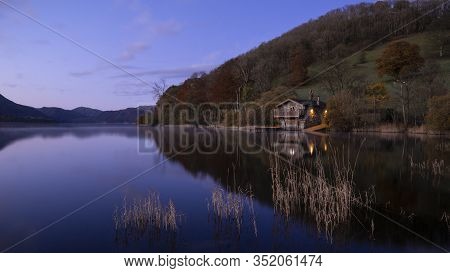 Stunning Sunrise Autumn Fall Landscape Image Of Ullswater In Lake District With Golden Sunlight