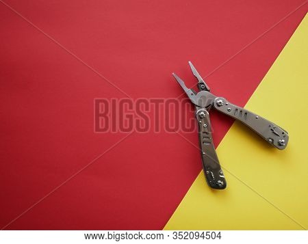Multi Tool With Steel Handles On A White Colored Paper Background. Top View