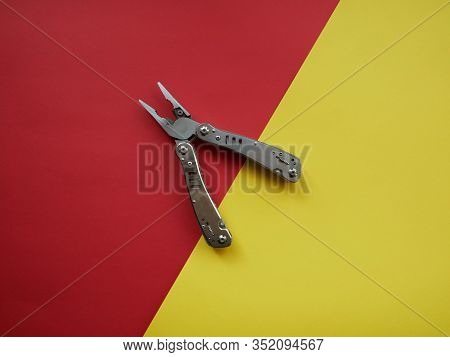 Multi Tool With Steel Handles On A White Colored Paper Background. Top View