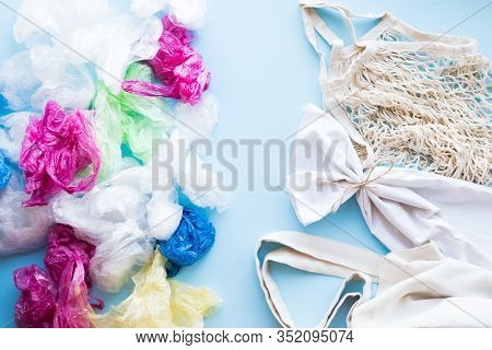 Many Disposable Plastic Bags Vs Reusable Cotton Bags On A Blue Background. Zero Waste Shopping. Sust
