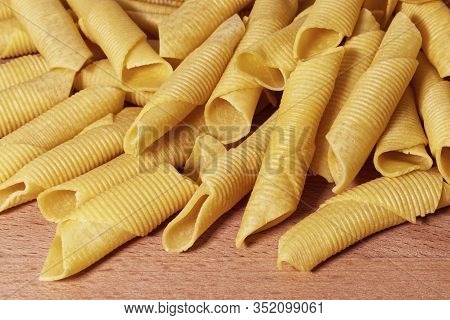 Maccheroni Al Pettine On Wooden Background. Raw Italian Pasta