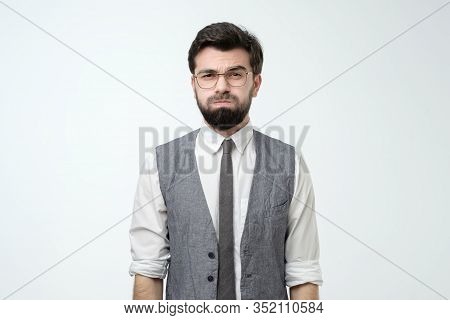 Young Man Looking Camera Puffing Out Cheeks From Resentment.