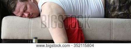 Portrait Of Bearded Alcoholic Had Rough Night Party. Male Drunkard Lying On Comfortable Sofa And Hol