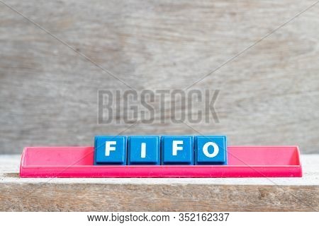 Tile Letter On Red Rack In Word Fifo (abbreviation Of First In First Out) On Wood Background