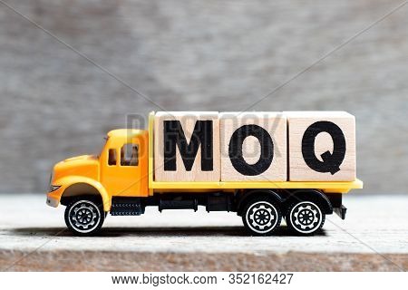 Truck Hold Letter Block In Word Moq (abbreviation Of Minimum Order Quantity) On Wood Background