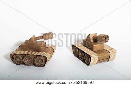 Two Toy Tanks Made By Children From Corrugated Cardboard Are Fighting. Toy Cardboard Tanks Isolated 