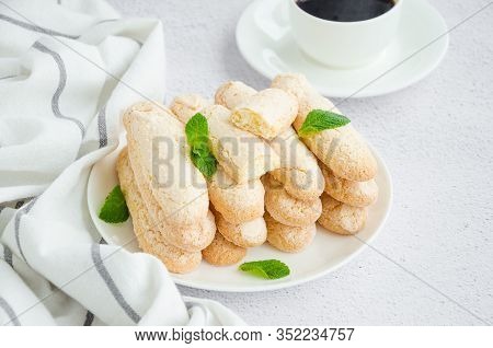 Homemade Traditional Italian Cookies Ladyfingers (savoyardi) On A White Plate On A Light Stone Backg