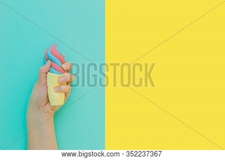 Flat Lay Antistress Toy Squish Ice Cream In Waffle Cone Squezzed In Hand.bright Blue Yellow Backgrou