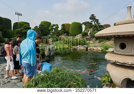 Saigon, Vietnam - December.12.2020: Group Of People Feeding Koi Fishes At Rin Rin Park In Saigon.