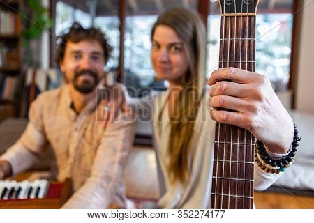 Closeup Of Shamanic Woman Holding Classical Guitar With Man Playing Musical Instrument Harmonium As 