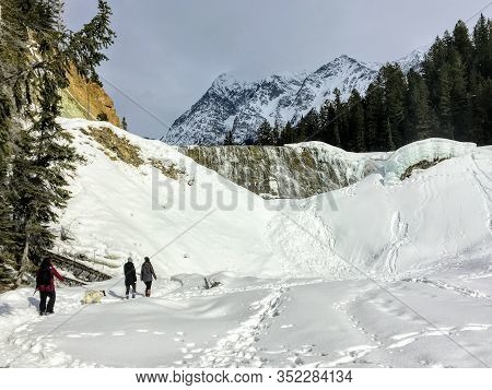 Yoho National Park, Canada - March 22nd, 2020: A Group Of Hikers Walking Towards The Frozen Wapta Fa