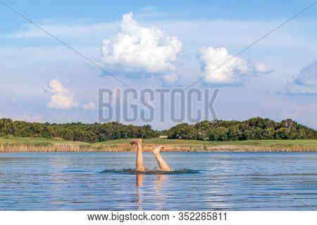 Man Legs Sticking Out From Water. Starting Swimming Season. Funny Photo. Enjoying Vacation. Bad Jump