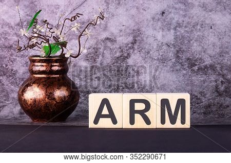 Word Arm Made With Wood Building Blocks On A Gray Background